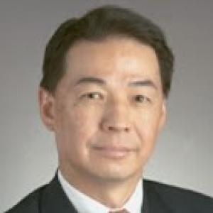 Head shot of David Wu wearing white shirt and tie with dark suit jacket.
